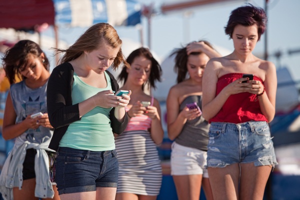 Young-women-using-smartphones-at-an-amusement-park.jpg