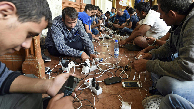 migrants_aap_1_cropped-phones.jpg